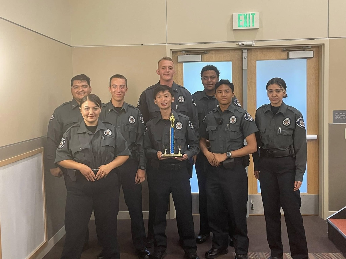 The Explorer team poses indoors with a first place trophy