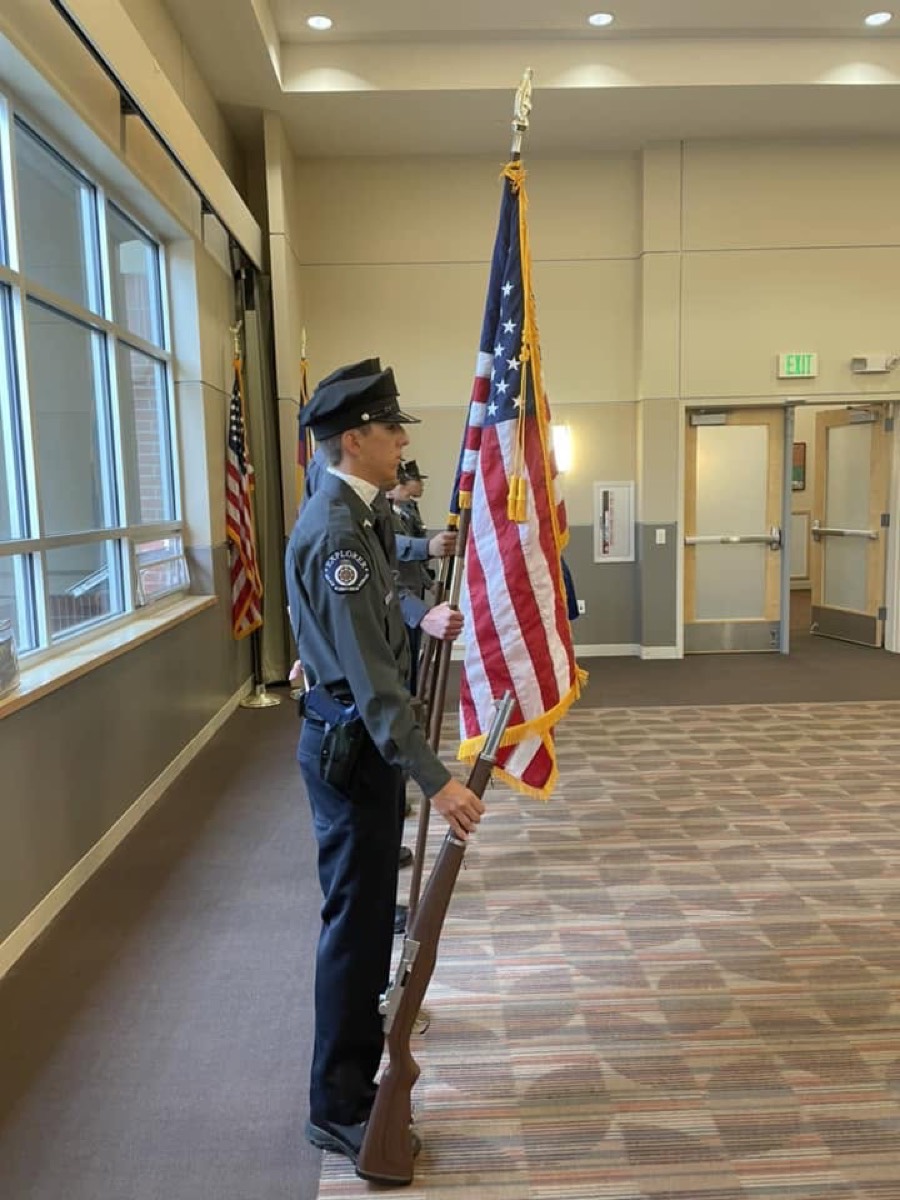 An Explorer stands post holding the American flag during a color guard detail